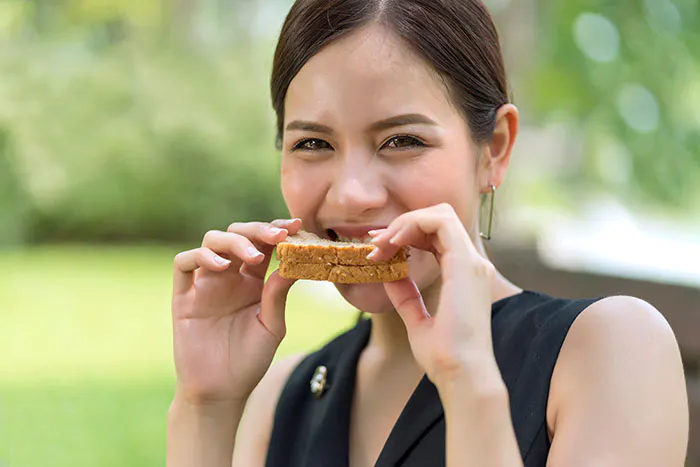 Asian-woman-eating-with-whole-wheat-sandwich-bread-with-chocolate-sauce